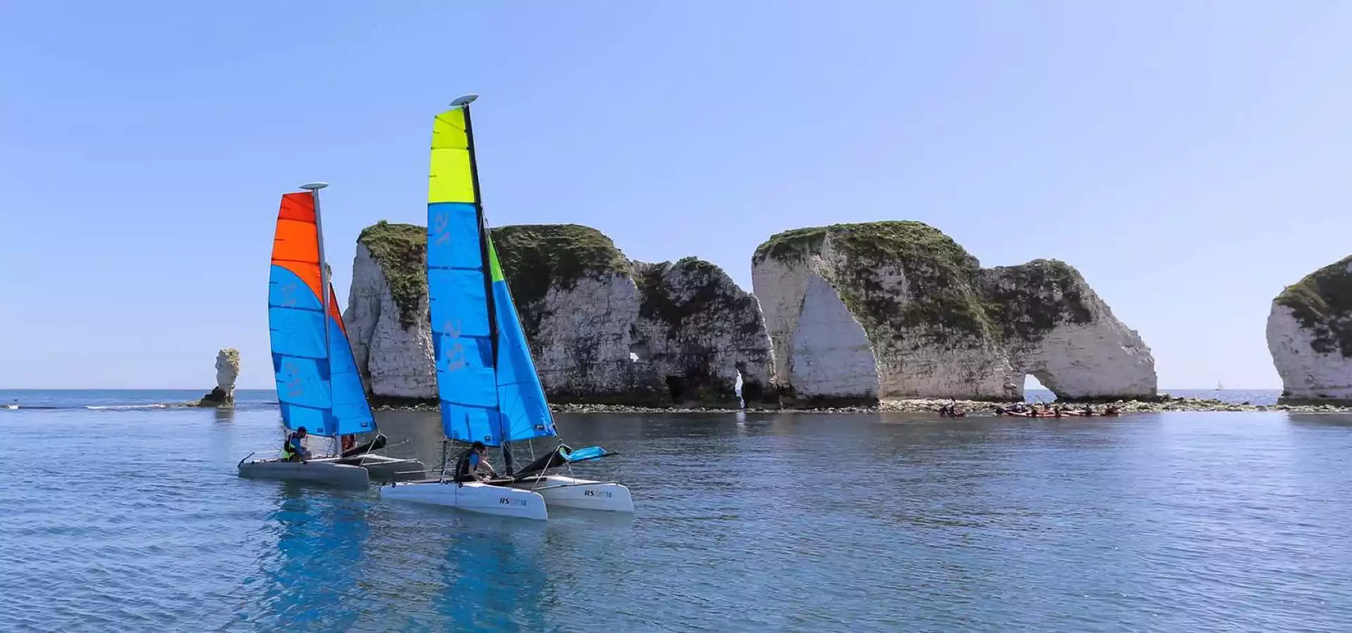 Zwei RS Sailing Cat segeln bei wenig Wind vor Insel
