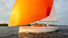 Daycruiser RS Aira segelt unter großem Gennaker mit großer Bugwelle.