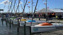Vier Aira 22 liegen nebeneinander im Hafen ohne Segel aber über die Tops geflaggt.