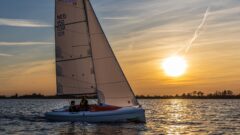 Enspanntes Segeln mit der RS Aira, einem offenem Kielboot, in der Abenddämmerung.