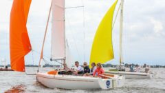 Vier Erwachsene sitzen auf der Luvbank von ihrem RS Aira 22 und segeln unter Gennaker neben einer weiteren RS Aira auch unter Gennaker.